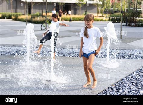 Happy kid playing in a fountain with water Stock Photo - Alamy