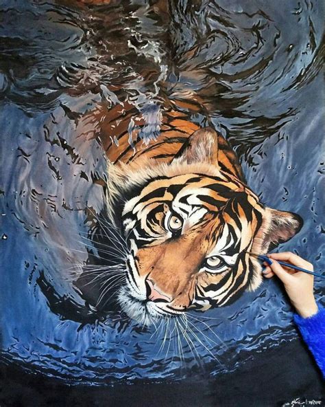 a painting of a tiger in the water is being painted by someone's hand