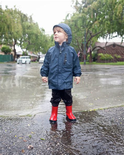 Caucasian boy standing in rain - Stock Photo - Dissolve