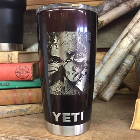 a stainless steel yeti coffee cup sitting on top of a table next to books