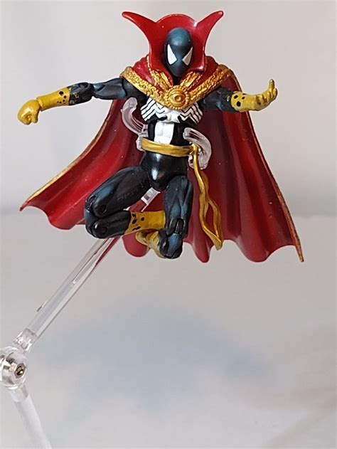 the action figure is wearing a red cape and holding two swords in one ...