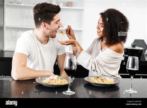 Beautiful young multiethnic couple having a romantic dinner at home ...