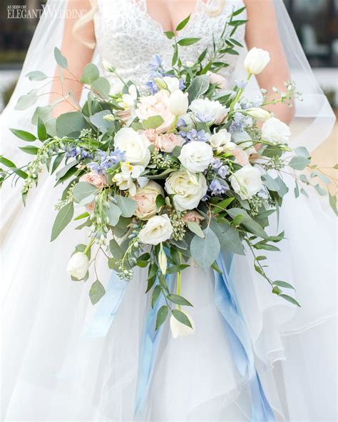 a bridal holding a bouquet of white and blue flowers