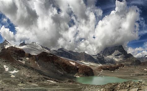 the mountains are covered in snow and clouds