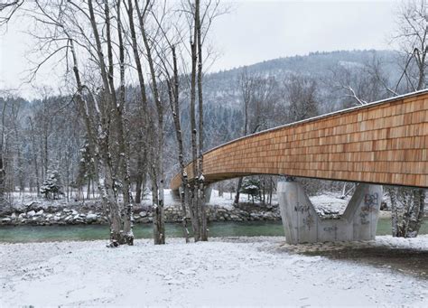 Architects create beautiful arched footbridge out of timber planks and ...