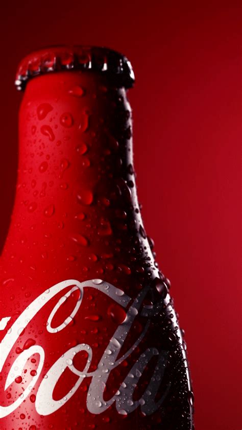 a close up of a coca cola bottle on a red background