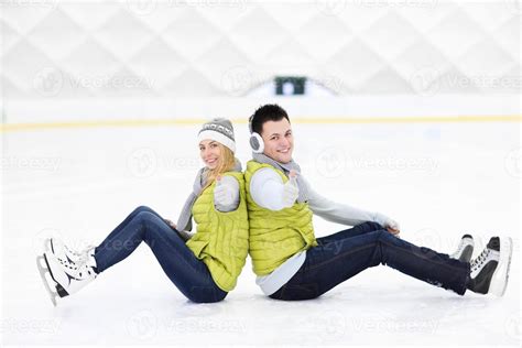 Cheerful couple sitting on the skating rink 15894233 Stock Photo at Vecteezy