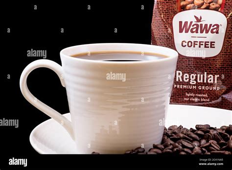 Wawa regular coffee bag close-up with a brewed cup of Wawa coffee, white mug on a white plate ...