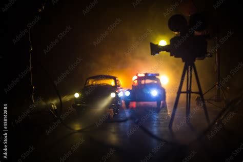 Action movie concept. Police cars and miniature movie set on dark toned ...