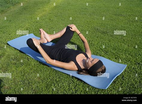 Girl doing advanced stretching exercises for the legs and groin with feet elevated - second ...