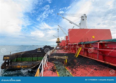 Loading Coal from Cargo Barges Onto a Bulk Carrier Using Ship Cranes ...