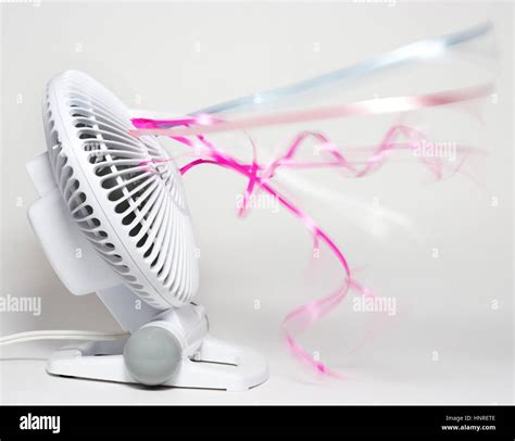 Table fan blowing colorful streamers Stock Photo - Alamy