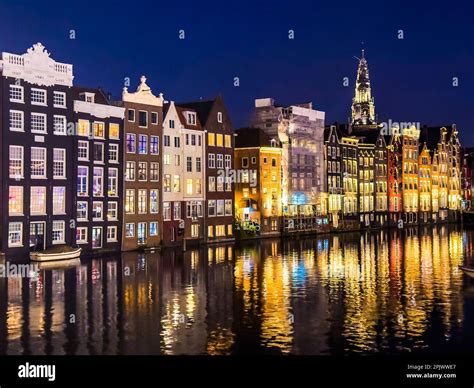 Damrak narrow houses at night in Amsterdam center, Netherlands Stock Photo - Alamy