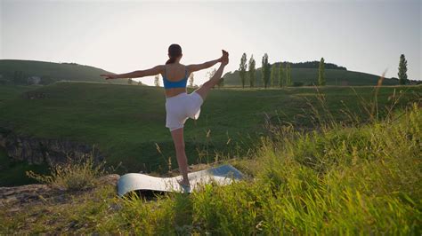 Athletic Woman Doing Yoga Poses on Top of a Mountain During Sunset. Sports Girl Trains and Does ...