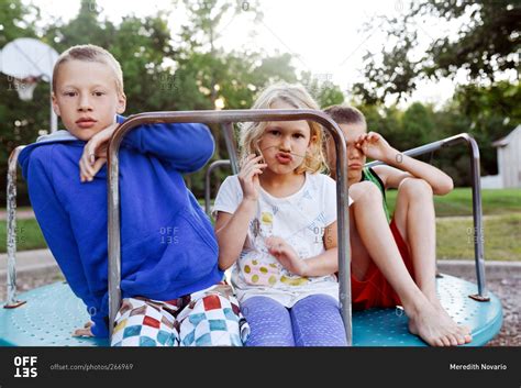 Children on a merry-go-round in a park stock photo - OFFSET