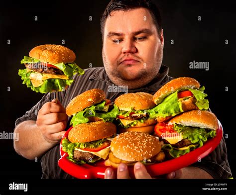 Fat man eating fast food hamberger. Breakfast for overweight person Stock Photo - Alamy