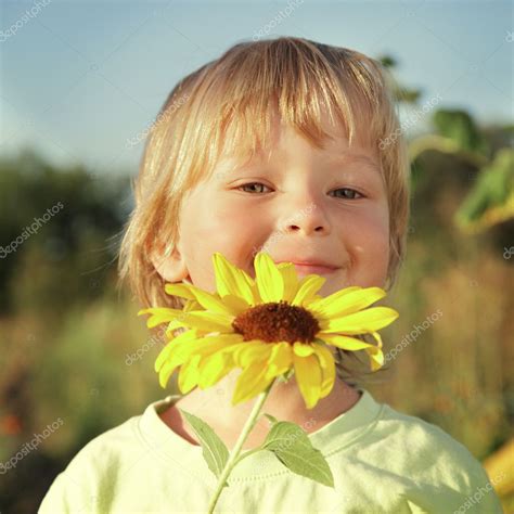 Happy boy with sunflower Stock Photo by ©chepko 58942647