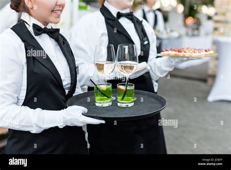 Midsection of professional waiters in uniform serving wine, cocktails Stock Photo: 145271190 - Alamy