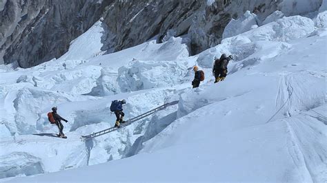 Wide shot of climber crossing a ladder in the Khumbu Icefall - Elia ...