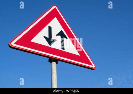 Road sign warning of two way traffic straight ahead England UK Stock Photo - Alamy