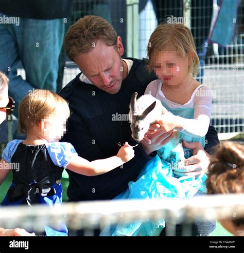 Ian Ziering and his daughters, Penna and Mia, play with a rabbit at the Studio City Farmers ...