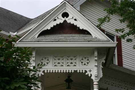 Detailed Fretwork on Ornate White House with Red Shutters