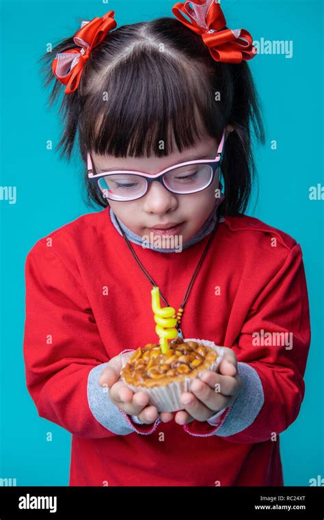 Dark-haired child with chromosome abnormality being extremely interested in cake Stock Photo - Alamy