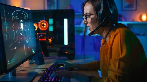 Pretty and Excited Gamer Girl in Glasses and Headset with a Mic Playing ...