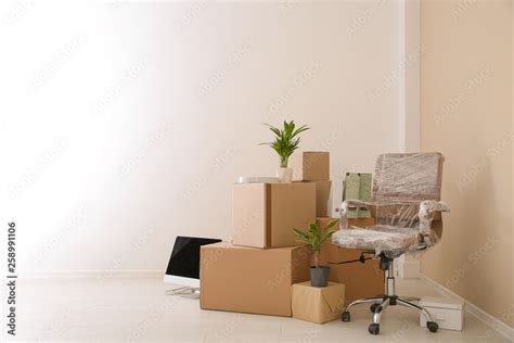 Moving boxes and furniture in new office. Space for text Stock Photo ...