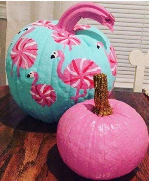 two painted pumpkins sitting on top of a wooden table