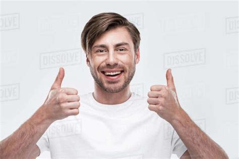 Handsome smiling man showing thumbs up, isolated on white - Stock Photo - Dissolve