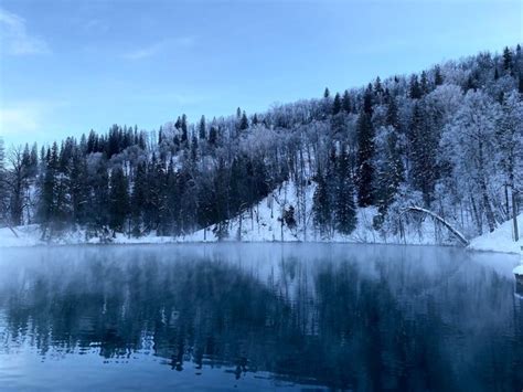 Premium Photo | A lake in the winter with snow on the trees and mountains