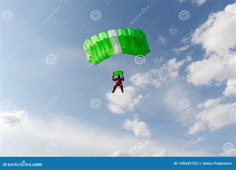 Skydiving. a Green Parachute and Red Skydiver are in the Sky. Stock ...