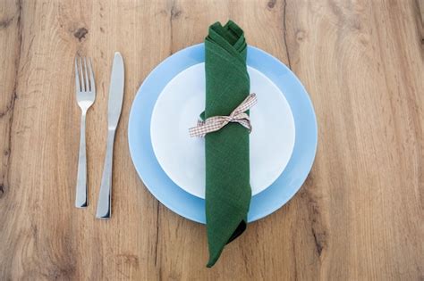 Premium Photo | Fork, knife, green napkin with plate