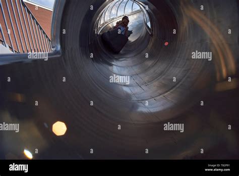 Kids enjoying the beautiful big metal slide at a playground in a park ...