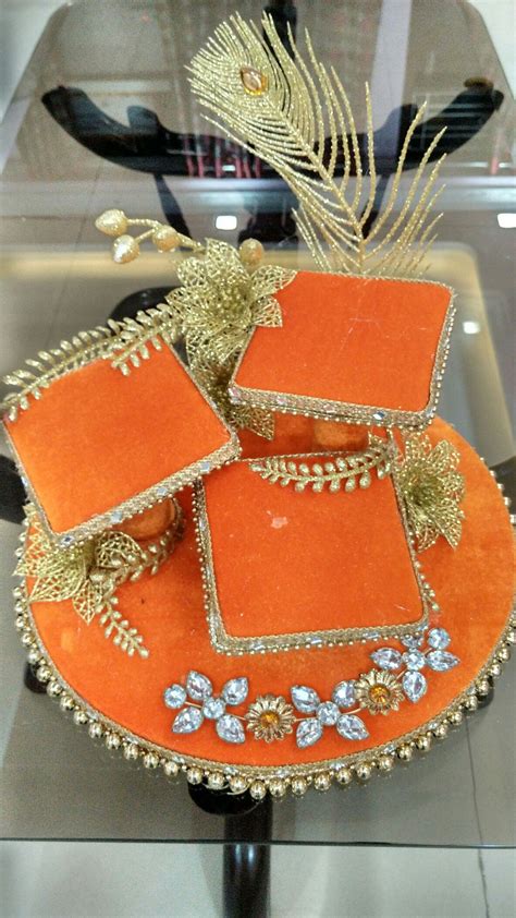 an orange hat with gold decorations and feathers on display in a glass ...