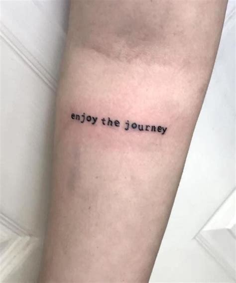 a tattoo saying enjoy the journey on someone's arm