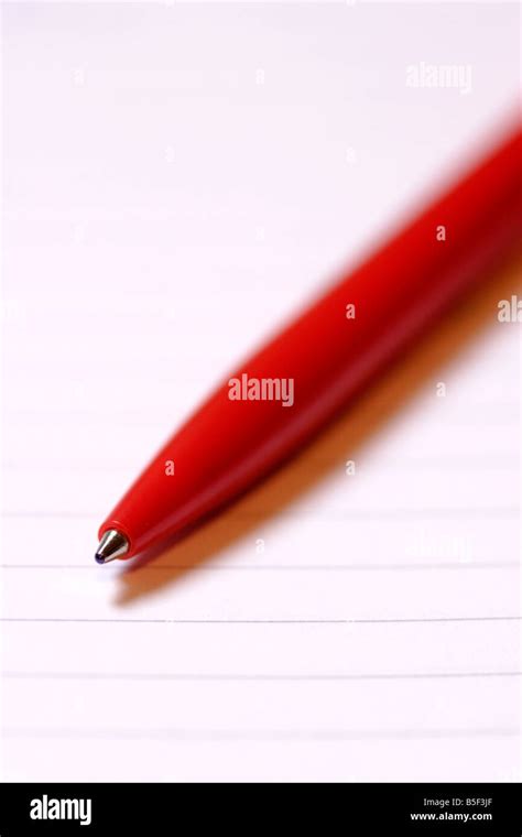 Red biro pen on lined paper close up Stock Photo - Alamy