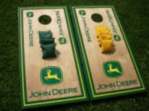 two cornhole game boards sitting on top of the grass with pieces of yellow and green