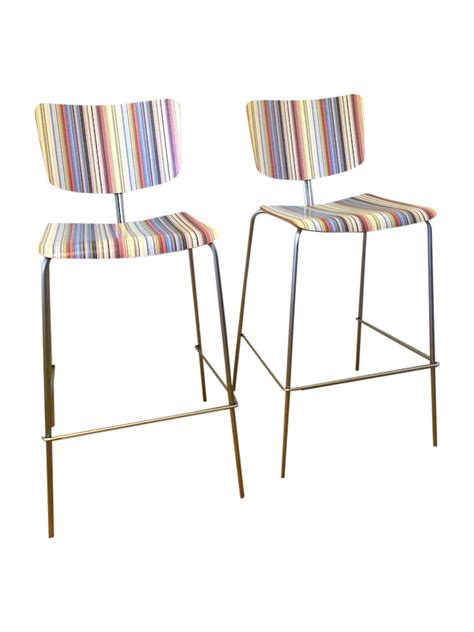 pair of bar stools with multicolored striped upholstered backrests