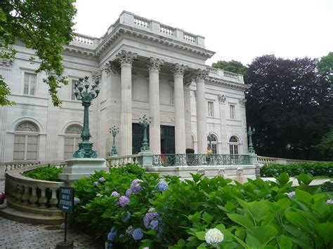 a large white building with pillars and columns on the front is surrounded by greenery