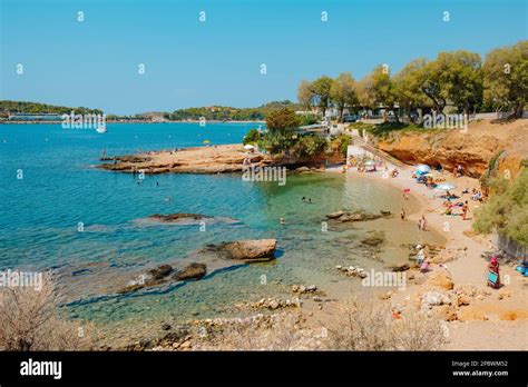 Vouliagmeni, Greece - September 1, 2022: Some people relax and enjoy the good weather in a small ...