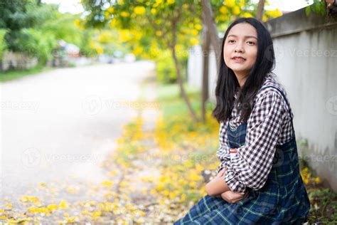 Young girl sitting on a bench reading a book under a beautiful tree. 8670519 Stock Photo at Vecteezy