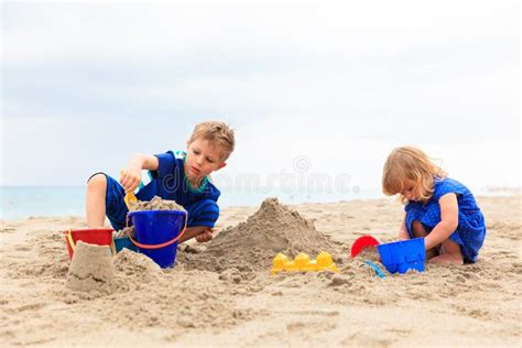 Juego De Los Niños Con La Arena En La Playa Del Verano Foto de archivo - Imagen de hermano ...