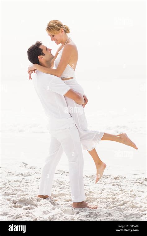 Man lifting woman on the beach Stock Photo - Alamy