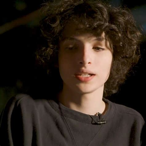 a close up of a person with curly hair wearing a black shirt and ...