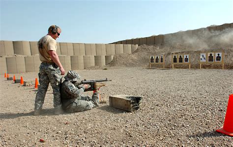 U.S. Army Sgt. Andy Butterworth, sitting, uses his prosthetic leg to ...