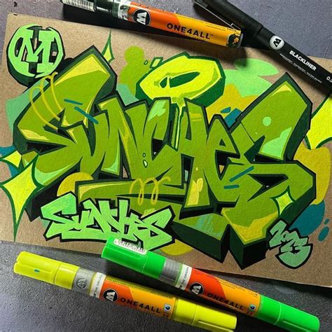 two markers are next to some graffiti on a piece of brown paper with green and yellow letters