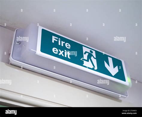 fire exit sign above green wooden door Stock Photo - Alamy