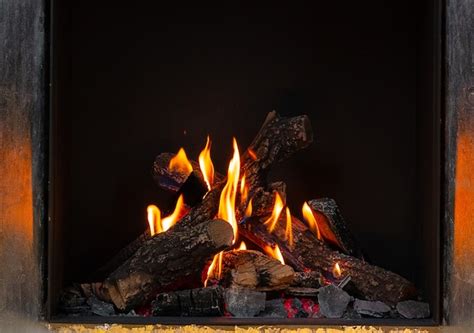 Premium Photo | Wood logs burning in fireplace close up